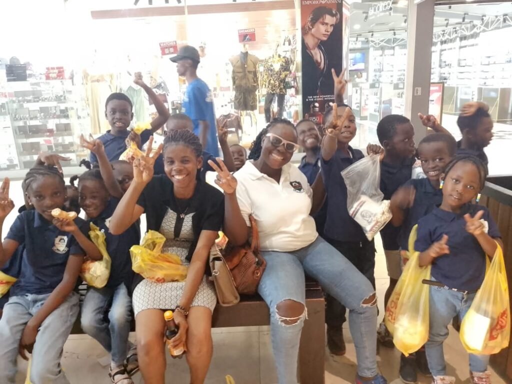 Teachers and pupils smiling together during a mall field trip